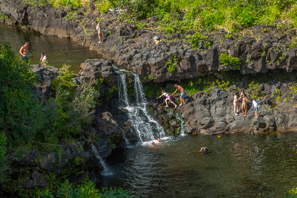 Swimmers and waterfall at Haleakalā National Park, Kipahulu on the Road to Hana in Maui.